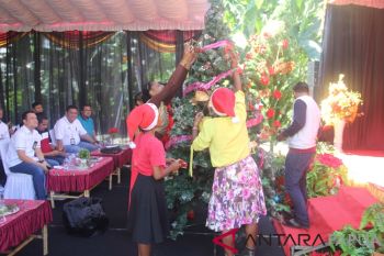 Anak-anak panti asuhan hias pohon Natal