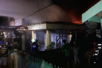Sebuah rumah terbakar saat hujan lebat turun