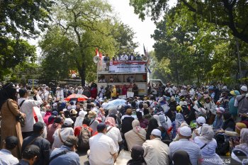 Massa mulai maju ke arah  barikade kawat berduri