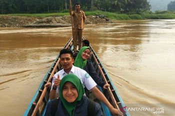 Petugas BPJS Kesehatan naik perahu sosialisasikan JKN KIS di Nagari Ulang Aling Selatan