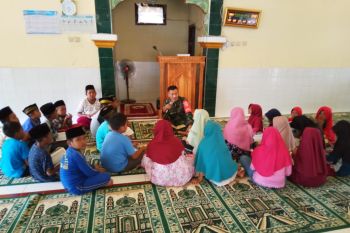 Seorang Anggota Kodim 1628/Sumbawa Barat jadi guru ngaji anak-anak