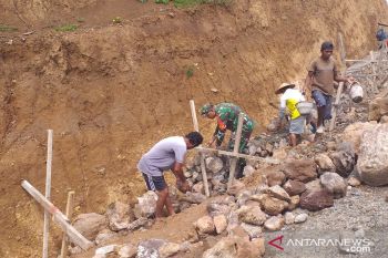 Babinsa  membantu warga kepulauan Siau perbaiki drainase