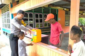 Bhabinkamtibmas Biak bagi jerigen cuci tangan ke warga cegah Corona