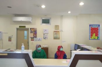 Perawat di ruang isolasi pompa semangat pasien agar sembuh