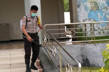 Bhabinkamtibmas Warsa Biak semprotkan cairan disinfektan di gereja