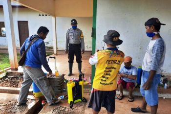Bhabinkamtibmas bersama warga Kampung Gurinda Jaya semprot cairan disinfektan