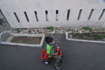 Bocah ini Asyik Bermain Dekat Kuburan di Tengah Jalan