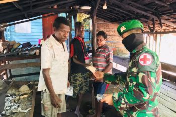 TNI lakukan penyemprotan disinfektan dan bagi masker warga kampung Rawa Biru Merauke