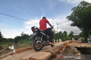 Warga melintas di jembatan darurat