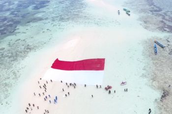 Prajurit TNI AL Lantamal VIII bentangkan Merah Putih di Pasir Timbul Nain