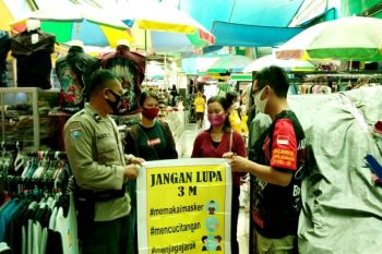 Personel Polsek Pahandut ingatkan pengunjung dan pedagang Pasar Besar terapkan 3M