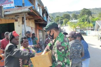 Prajurit Satgas Yonif Raider 500/Sikatan bagi masker warga di Enarotali
