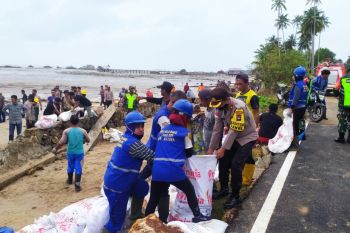 Polres  Natuna bersama TNI dan warga bangun  tanggul karena ombak besar