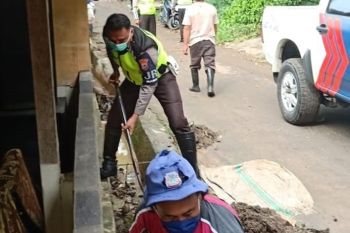 Personel Polantas Polda Sulut bantu warga bersihkan material banjir Manado