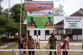 Babinsa Koramil Yapsel bersama warga Kampung Kainui II pasang banner siap divaksin