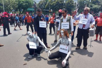 Buruh menggelar aksi teatrikal manusia silver dan pengusaha