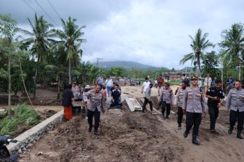 Polisi memberikan bantuan kepada korban banjir di Lombok Tengah