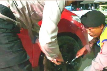 Penuh dedikasi, polisi ganti ban mobil penonton WSBK yang pecah