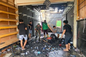 Babinsa bersama warga bersihkan sisa kebakaran toko di Supiori