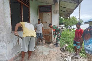 Posramil Warsa bantu warga campur semen untuk pembangunan rumah