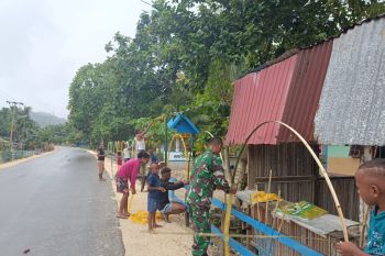 Posramil Warsa membantu warga membuat hiasan Natal di sepanjang jalan