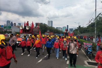 Massa kelompok buruh berjalan kaki menuju depan gedung DPR RI