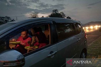 Pemudik berbuka puasa dengan bekal di sekitar rest area
