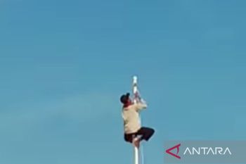 Ketua RT  panjat tiang bendera saat upacara HUT kemerdekaan