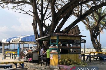 Santai di pinggiran Pantai Talise dengan minuman es kelapa yang menyegarkan