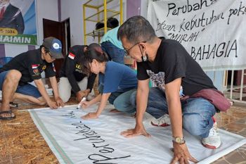 Relawan Mileanies memanfaatkan karung bekas buat spanduk capres