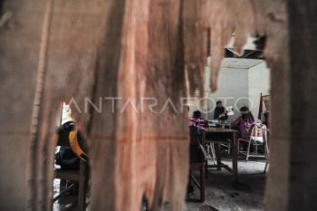 Siswa belajar di ruang kelas rusak
