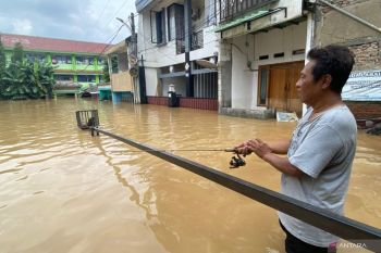 Banjir Jakarta, warga milih mancing di depan MTSN 23 Jakarta