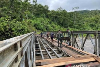 Satgas Yonif 641/Bru dan warga perbaiki jembatan penghubung Papua Pegunungan