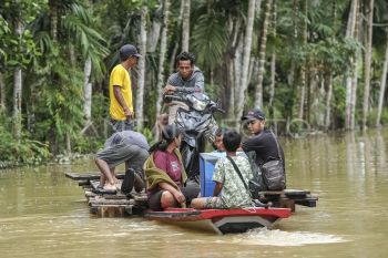 Jasa penyeberangan motor di lokasi banjir Tebo