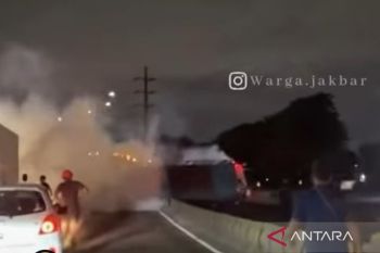 Sebuah truk terbalik dan keluarkan asap di flyover Pesing Jakarta Barat