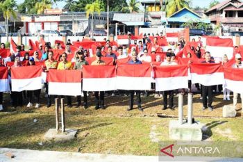 Warga perbatasan RI-RDTL mengarak bendera merah putih raksasa