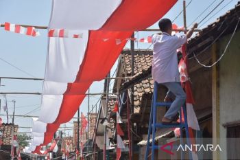 Spirit of nationalism unfurls with giant flag across narrow alley