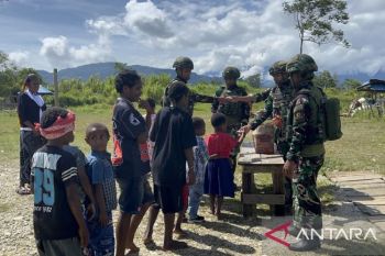 Satgas  TNI Yonif 521/DY bagi makanan ringan ke warga Kobakma Mamteng