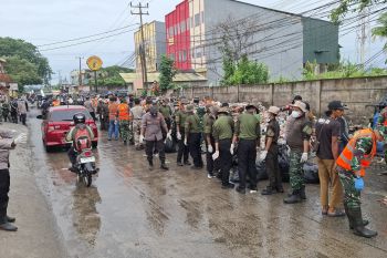 Petugas Polri dan TNI bersihkan sampah di sudut jalan di Tangerang