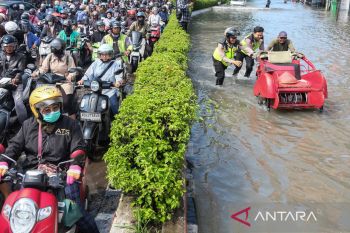 Polisi dan relawan bantu pengguna jalan di tengah banjir