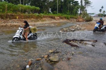 Warga menyeberangi sungai di Padang