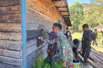 Prajurit Satgas Yonif 511/DY mengecat rumah tokoh masyarakat Lowanom