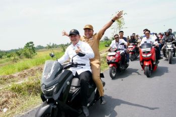Dudung Abdurachman naik motor ke persawahan meninjau saluran irigasi di Deli Serdang