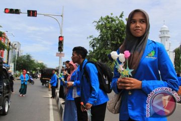 Murid membagikan bunga kepada guru saat Hardiknas