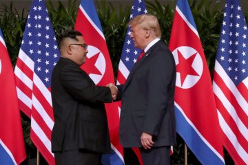 Donald Trump dan Kim Jong Un akhirnya berjabat tangan