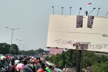 Pria pemanjat papan baliho jadi tontonan warga