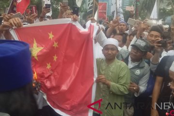 Massa bela Uighur bakar spanduk bendera China