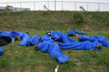 Migran tidur di tanah, atap pengeboran minyak di perbatasan Texas