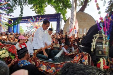 Gaya Ma'ruf Amin bagikan kaos di atas kereta kencana