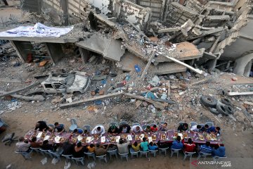 Warga Palestina berbuka puasa di lokasi bekas serangan udara Israel